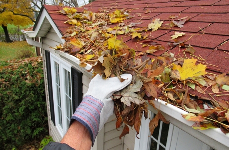 Homeowner cleaning gutters to prevent water damage in Texas